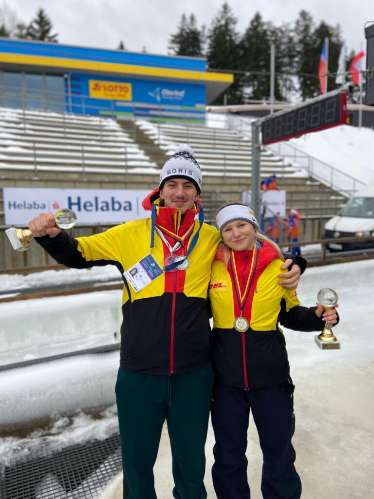 Malou und Tizian stehen zusammen und schauen in die Kamera mit Kristallkugeln in der Hand.